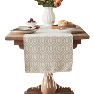 Beige and white jacquard table runner with geometric mountain pattern and tassels