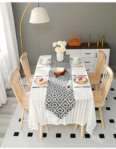 Detail of white striped tablecloth with Moroccan geometric runner and elegant tassels