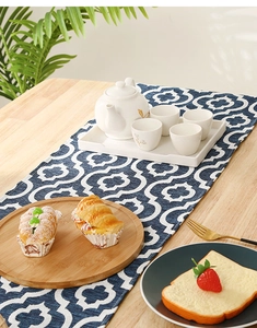 Detail of dark blue table runner with white geometric patterns on a wooden table