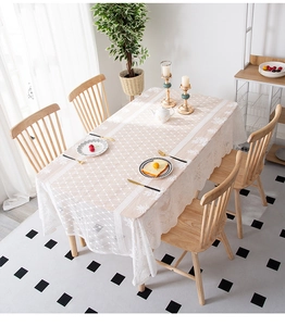Detailed close-up of white lace tablecloth featuring floral embroidery and mesh texture
