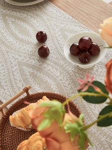 Dettaglio del runner da tavolo jacquard beige con motivi floreali e lino