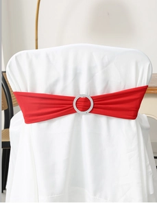Detail of red elastic chair sash with circular rhinestone buckle on a white chair cover