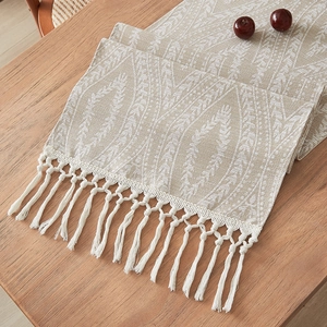 Runner da tavola in lino beige con motivo jacquard di foglie e nappine bianche