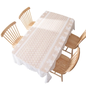 Elegant white lace tablecloth with floral hollow patterns on a wooden dining table