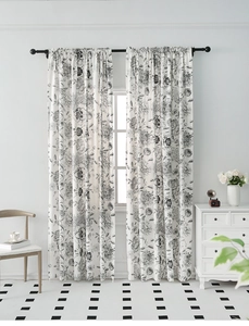 Detail of French floral curtains in black and white hanging on a black metal rod