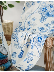 Detail view of cotton linen curtain fabric with blue floral and grape pattern print