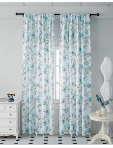Detailed view of floral curtains with light blue botanical patterns on a white fabric