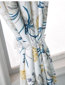 Close-up of floral cotton linen curtain with elegant white mesh flower tieback and pearls