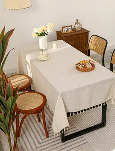 Close-up of minimalist oatmeal cotton linen tablecloth with elegant tassel fringe details