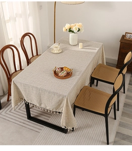 Detail of light grey rectangle tablecloth showing linen texture and beige tassel fringe