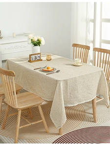 Detail of beige linen rectangular tablecloth with natural texture and elegant drape