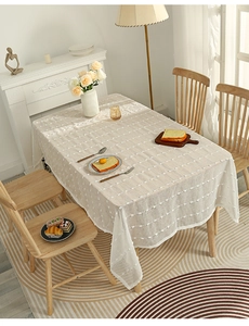 Detail of beige rectangular tablecloth featuring white textured 3D polka dot stripe patterns