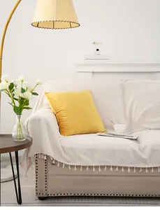 Detail of soft yellow velvet throw pillow on a modern sofa with cozy home decor atmosphere