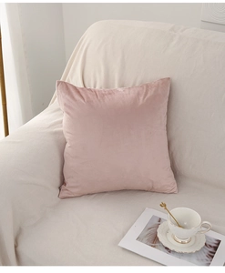 Detailed texture of dusty pink velvet pillow cover on a modern white sofa set