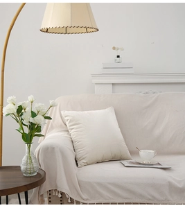 Detailed texture of a cream velvet square cushion cover in a minimalist home setting