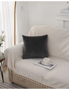 Close-up of luxury dark grey velvet cushion cover on a soft sofa in a modern home