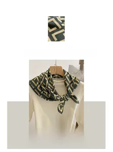Detail of green and beige square scarf featuring geometric embroidery and linen fabric