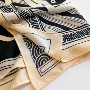 Detailed view of black and white geometric pattern scarf with herringbone texture weave