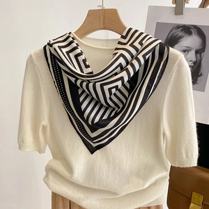 Chic black and white geometric stripe silk scarf with a beige short sleeve knit sweater