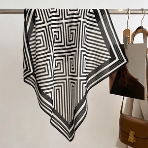 Detail of soft black and white geometric pattern scarf draped on a display rack