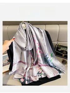 Detail of silk-satin scarf featuring elegant pink lotus print and soft lavender texture