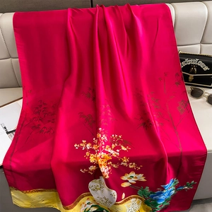 Elegant rose red faux silk scarf with traditional Chinese floral patterns on a sofa