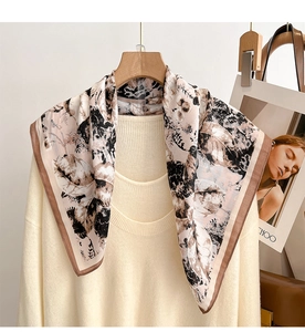Detail of elegant silk-like square scarf with earthy floral print on a white knit sweater