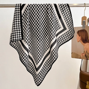 Detailed view of houndstock pattern silk scarf with elegant black and white borders