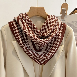Classic houndstooth scarf in brown and beige draped over a suit on a wooden hanger