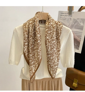 Detail of floral silk scarf with dark brown trim paired with a white knitted top