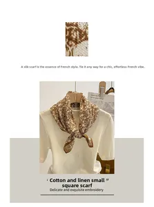 Detail of floral brown and white cotton linen scarf paired with a white knit top