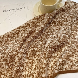 Detail of floral printed neck scarf with premium hemmed edges on a vintage background