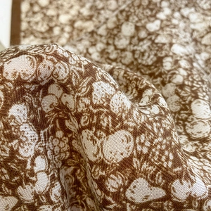 Detail of vintage floral scarf fabric with strawberry patterns in warm brown tones