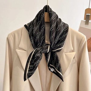 Fashionable black and white alphabet printed silk scarf styled on a beige blazer collar