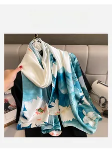 Detailed view of the elegant lotus print and smooth silk-like satin texture of the scarf