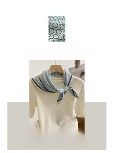 Detail of light blue cotton linen scarf with black ring pattern on white knitwear