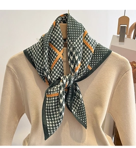 Détail d'un foulard pied-de-poule vert foncé avec rayure orange THEANOR sur tricot beige
