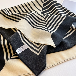 Detail of striped cotton linen scarf showing fabric weave and satin product label