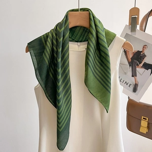 Minimalist green and black striped fashion scarf draped on a white vest top