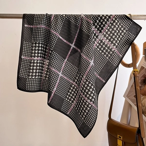 Texture détaillée du foulard en soie pied-de-poule avec accents violets sur barre