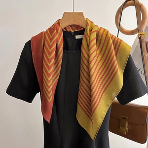 Minimalist striped square scarf in orange and ginger yellow hanging on wooden hanger