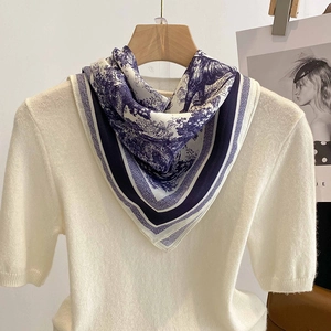 Eleganter Seidenschal mit blauem Print kombiniert mit cremefarbenem Strickoberteil