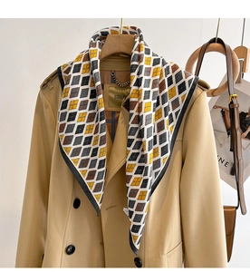 Detail of geometric diamond pattern scarf tied on a classic khaki double-breasted trench coat