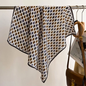 Detailed view of argyle knit scarf in brown and grey hanging with fashion accessories