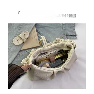 Detail of the pleated cloud bag interior showing capacity for cosmetics and a phone