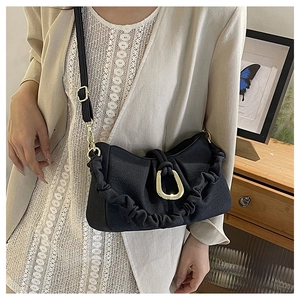 Detail view of black ruched crossbody bag with U-shaped gold hardware buckle and adjustable strap
