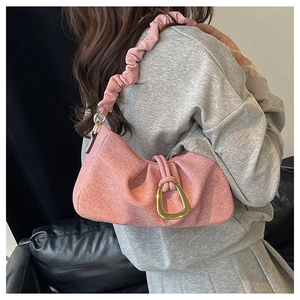 Close-up of pink ruched cloud bag with large gold buckle and matching shoulder strap