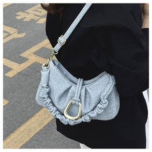 Detail of grey pleated cloud bag showing fabric texture and horseshoe metal buckle