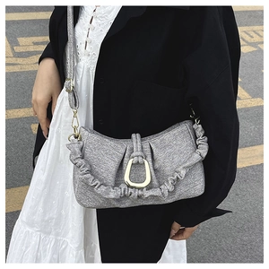Detail of grey pleated shoulder bag with golden horseshoe buckle and textured fabric