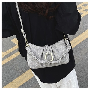Detail of light grey textured cloud bag with gold U-shaped buckle and ruched strap